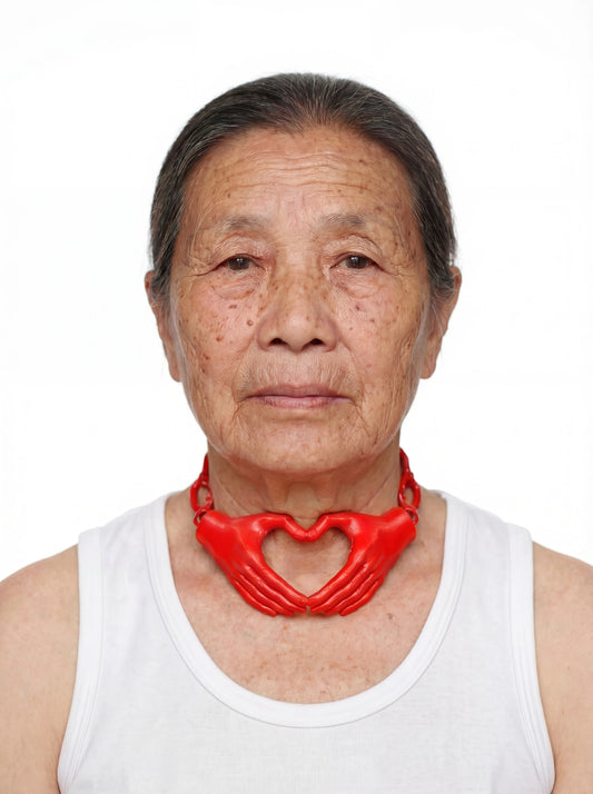 Red heart hands necklace worn with white tank on white background