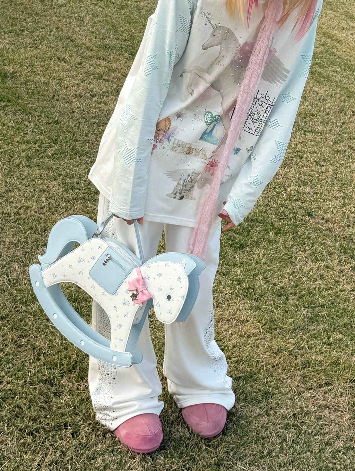 CFIERCE Rocking Horse Crossbody Handbag - blue floral rocking-horse handbag held close to outfit