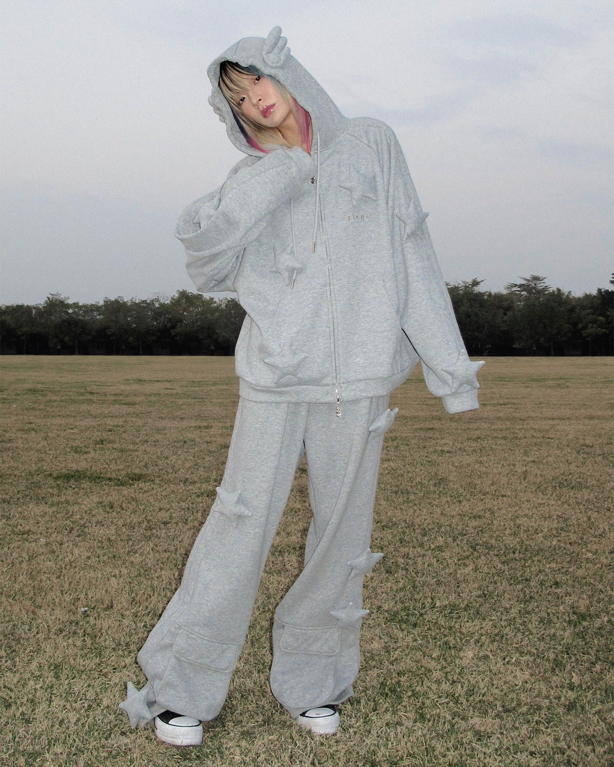 CFIERCE Raised Star Flared Sweatpants - gray raised-star flared sweatpants worn while posing on grass