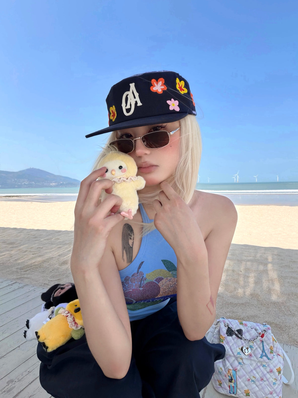 SANB Hwa floral embroidered cap worn on beach, front three-quarter view