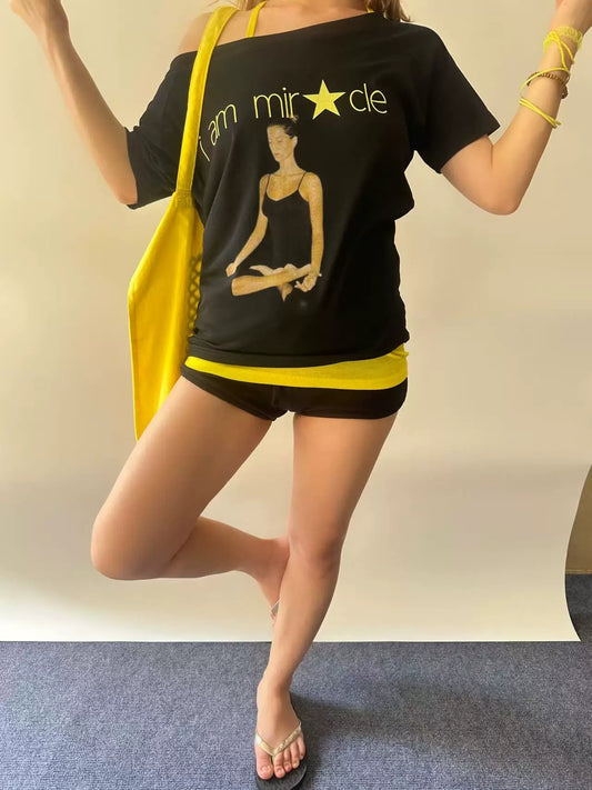 RebelAngel Miracle black graphic tee with yellow bag styling