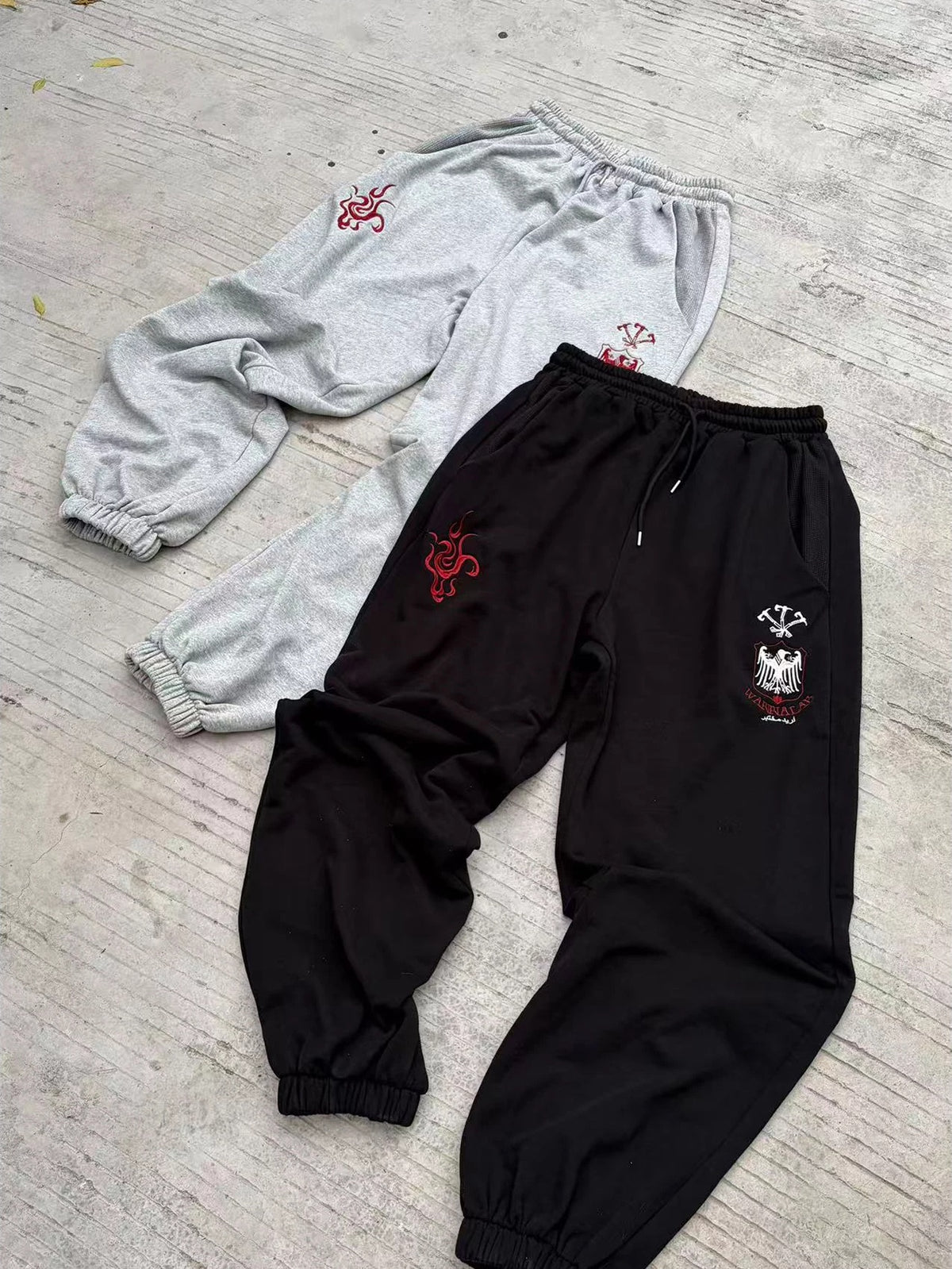 WANNA LAB Greyhound Flame Embroidered Cuffed Wide Sweatpants - Black & Gray front flat lay