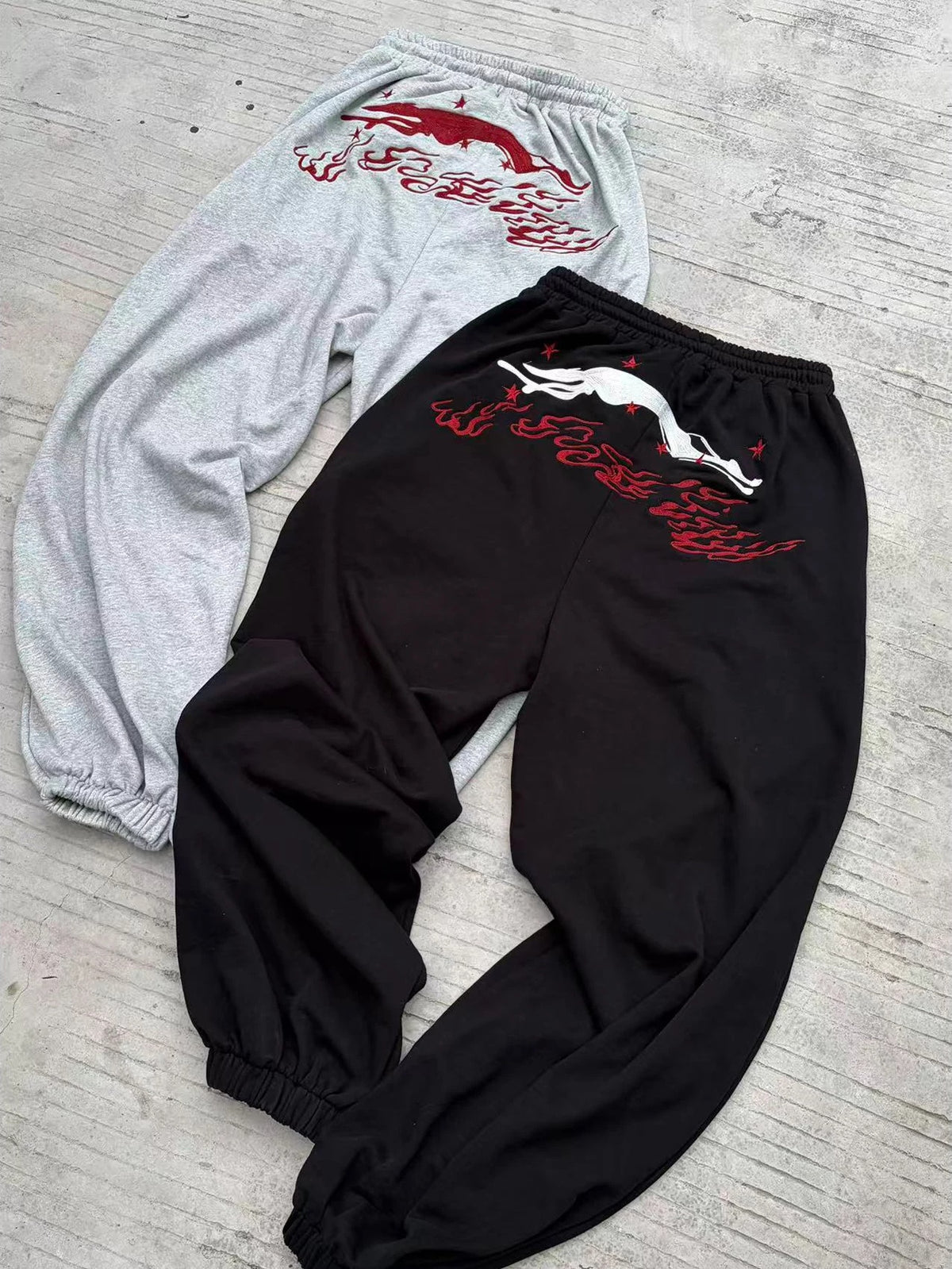 WANNA LAB Greyhound Flame Embroidered Cuffed Wide Sweatpants - Black & Gray back flat lay