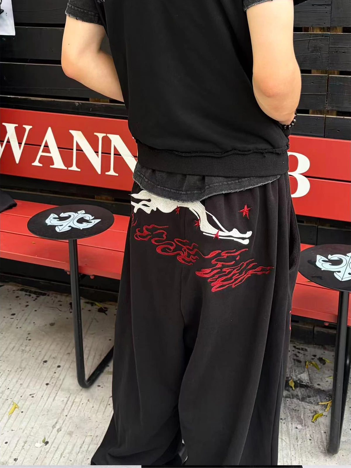 WANNA LAB Greyhound Flame Embroidered Cuffed Wide Sweatpants - Black back on model