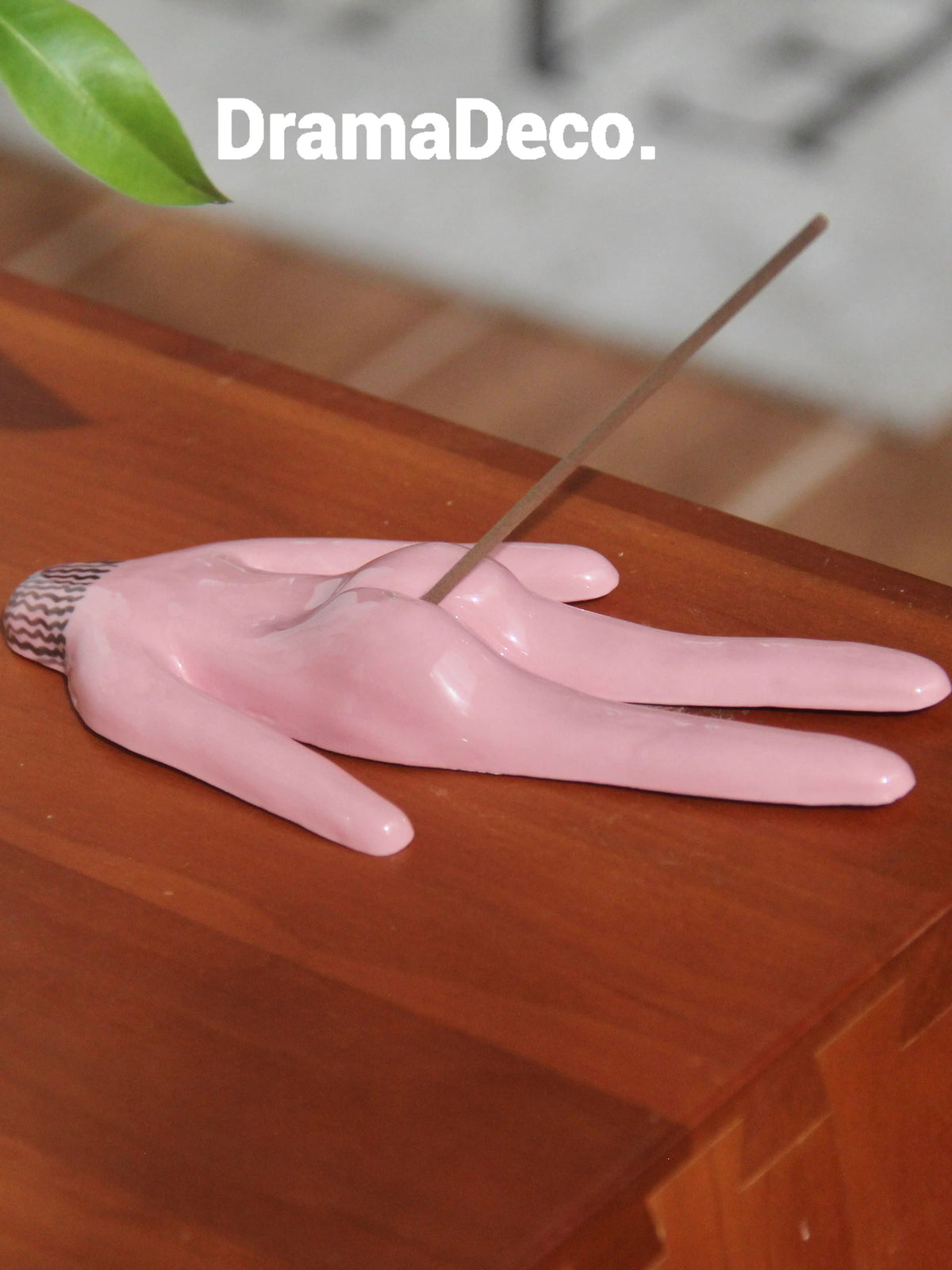 Pink ceramic incense holder on wooden tabletop