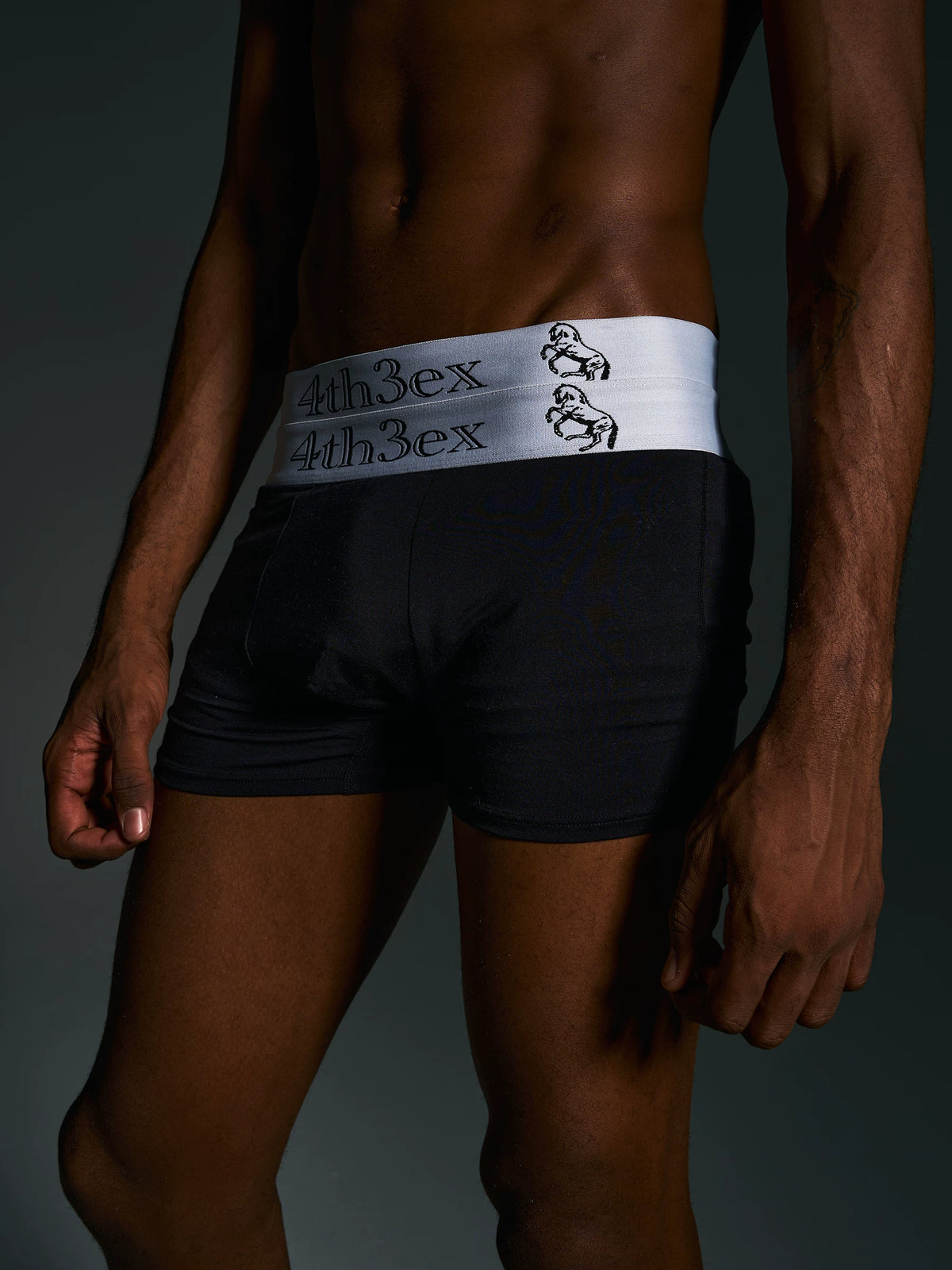 Angled front view of black boxer briefs worn on model