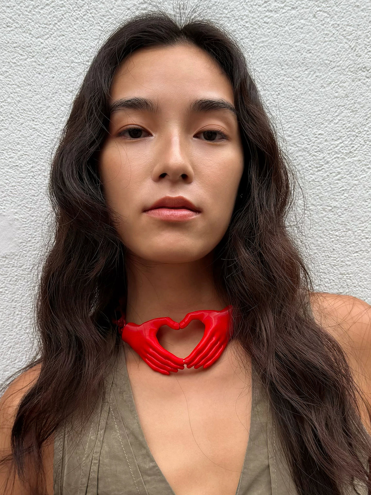 Red heart hands necklace worn with olive top