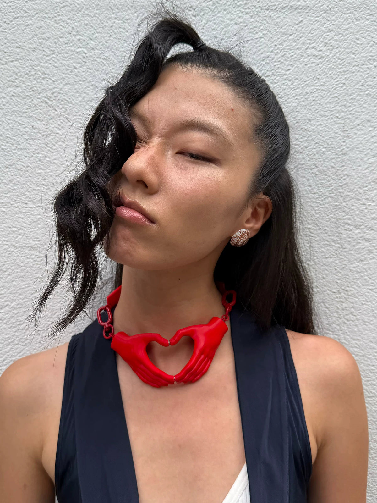 Red heart hands necklace styled with navy vest